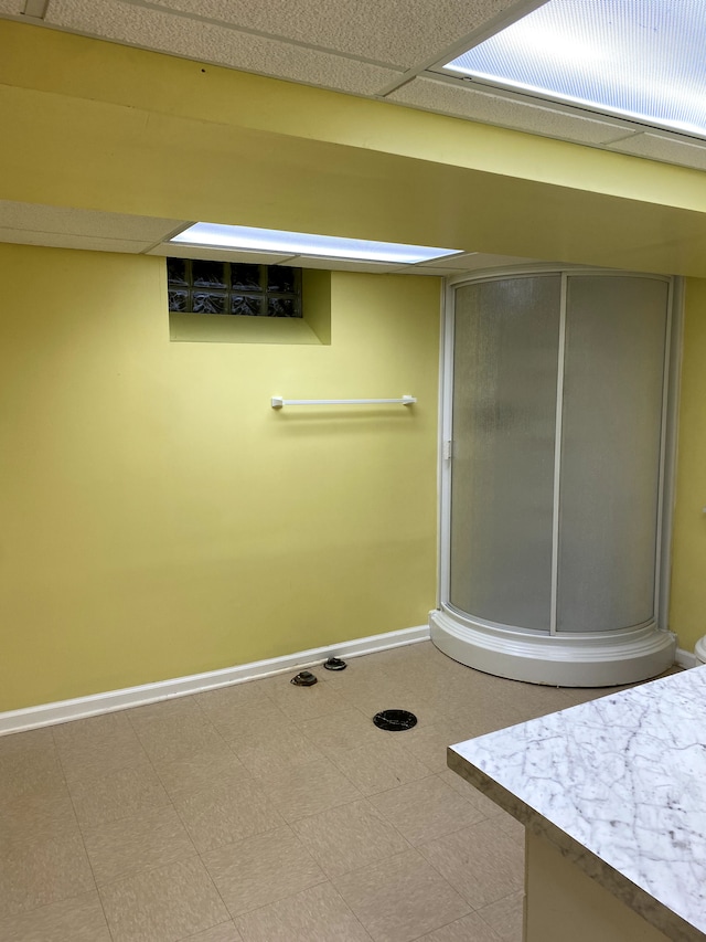 bathroom with a shower with door and a paneled ceiling