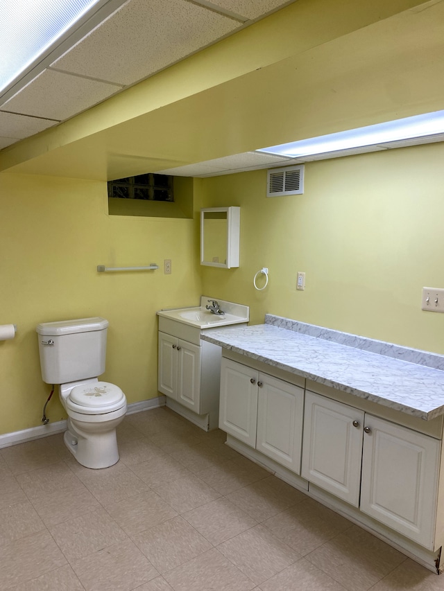 bathroom with vanity, a paneled ceiling, and toilet