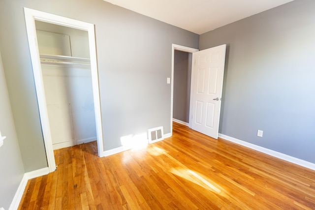 unfurnished bedroom with light hardwood / wood-style floors and a closet