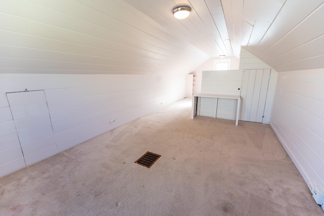 additional living space featuring vaulted ceiling and light carpet