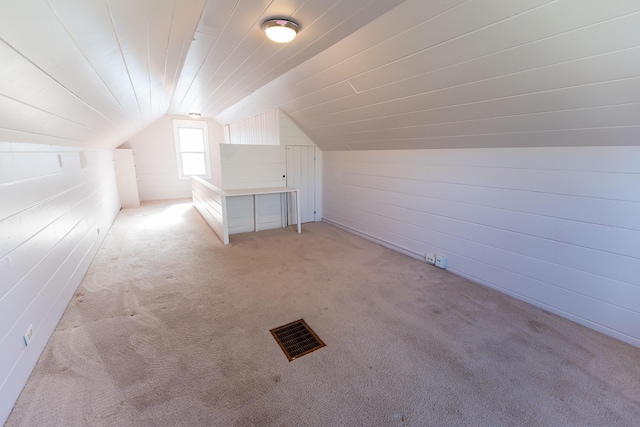 bonus room featuring vaulted ceiling and light carpet