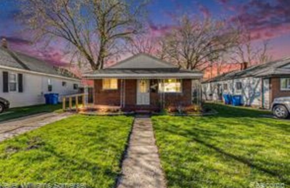 bungalow-style house with a lawn and a porch