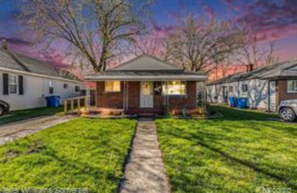 bungalow-style home with a porch and a lawn