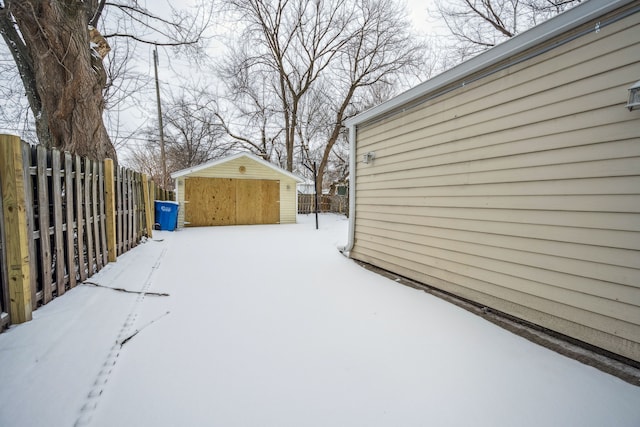 yard covered in snow featuring an outbuilding