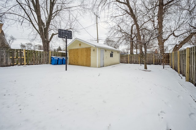 snowy yard featuring a storage shed