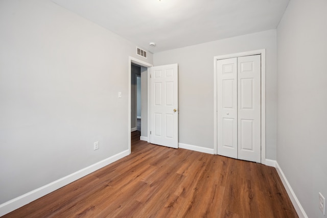 unfurnished bedroom with hardwood / wood-style floors and a closet