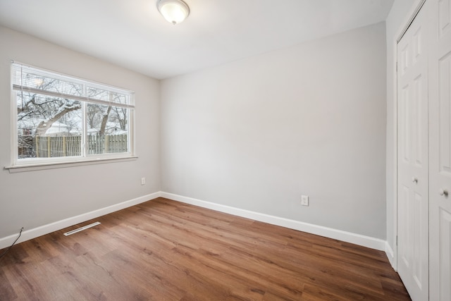 unfurnished bedroom featuring hardwood / wood-style floors and a closet