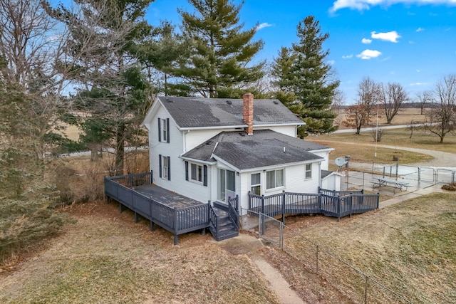 rear view of house with a wooden deck and a yard