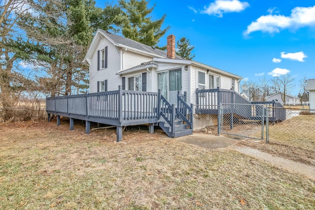 view of front of property featuring a wooden deck and a front lawn