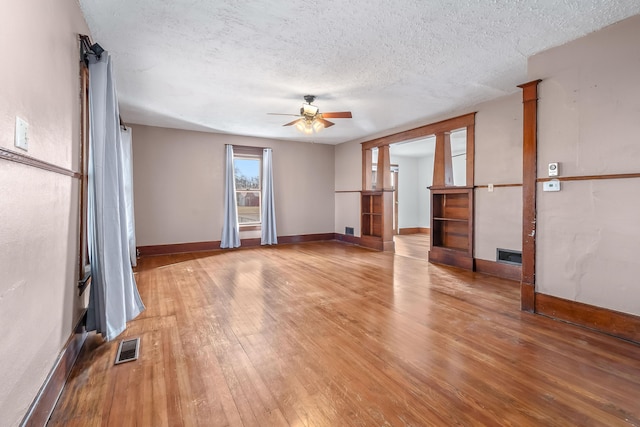 empty room with hardwood / wood-style floors, a textured ceiling, and ceiling fan