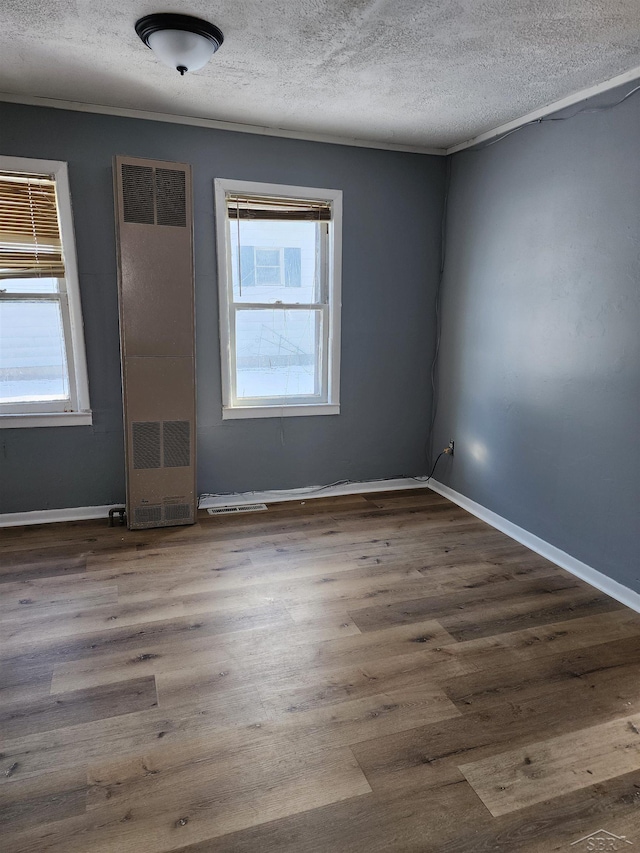 unfurnished room featuring a textured ceiling and dark hardwood / wood-style flooring