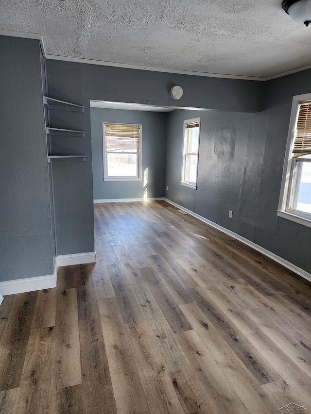 empty room featuring hardwood / wood-style flooring and a textured ceiling