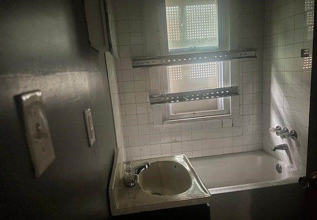 bathroom with tiled shower / bath combo and sink