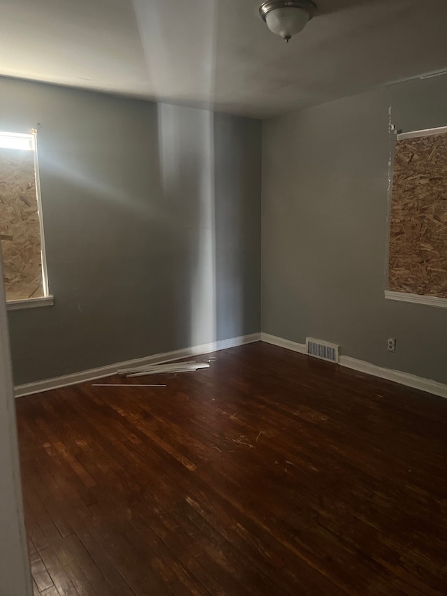 spare room featuring dark wood-type flooring