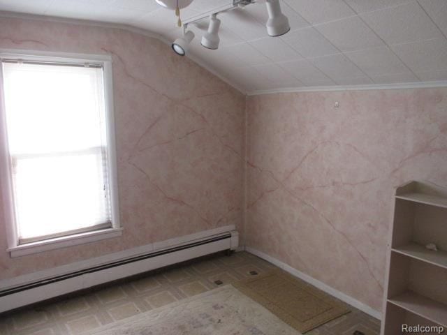 additional living space with a baseboard radiator and vaulted ceiling