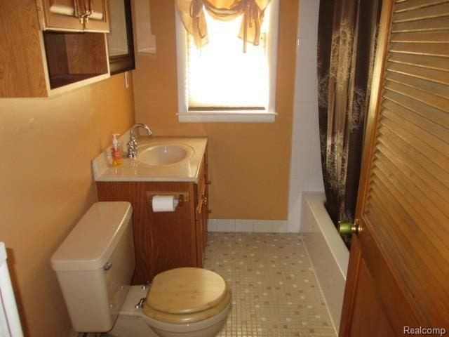 full bathroom with vanity, shower / bath combo, and toilet