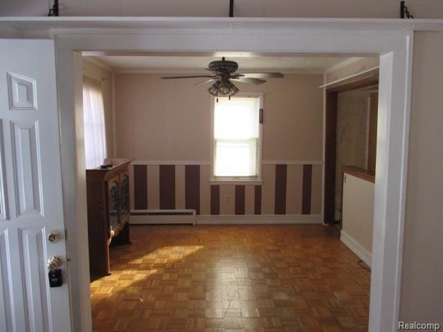 empty room with a baseboard radiator, dark parquet flooring, and ceiling fan