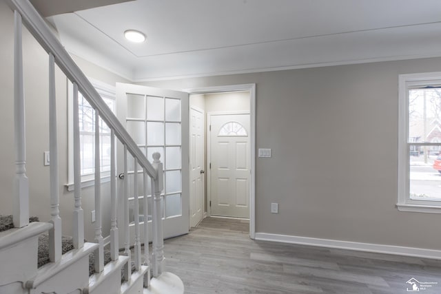 entrance foyer with hardwood / wood-style floors and crown molding