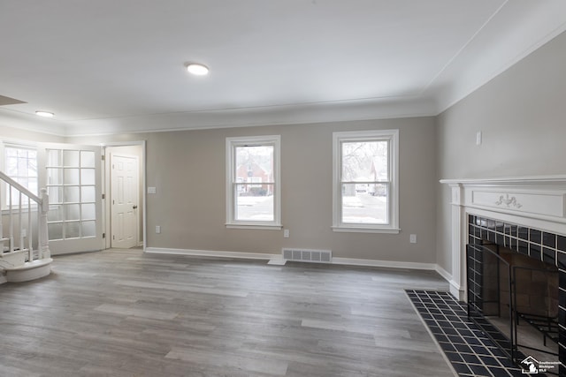 unfurnished living room with crown molding, hardwood / wood-style flooring, and a fireplace