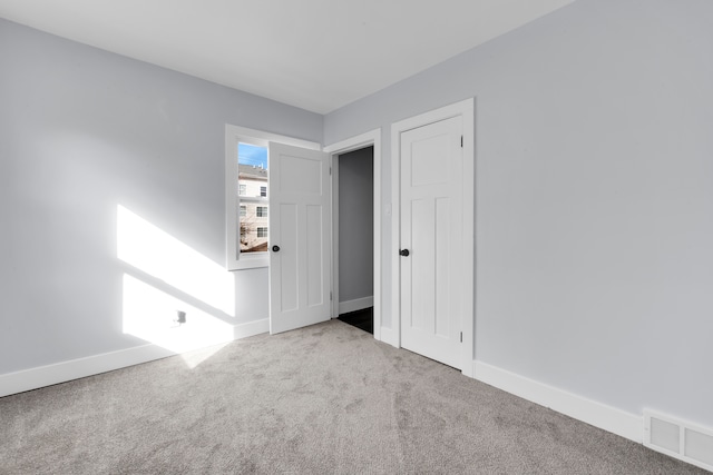 unfurnished room featuring light carpet