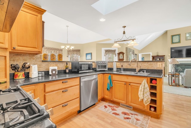 kitchen featuring hanging light fixtures, sink, stainless steel dishwasher, and kitchen peninsula