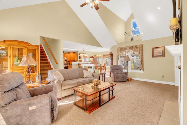 carpeted living room with ceiling fan and high vaulted ceiling