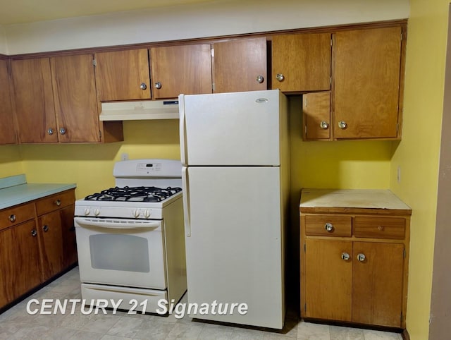 kitchen with brown cabinetry, white appliances, and under cabinet range hood