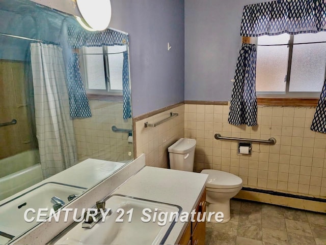 full bathroom featuring a baseboard radiator, tile walls, vanity, toilet, and shower / bath combo