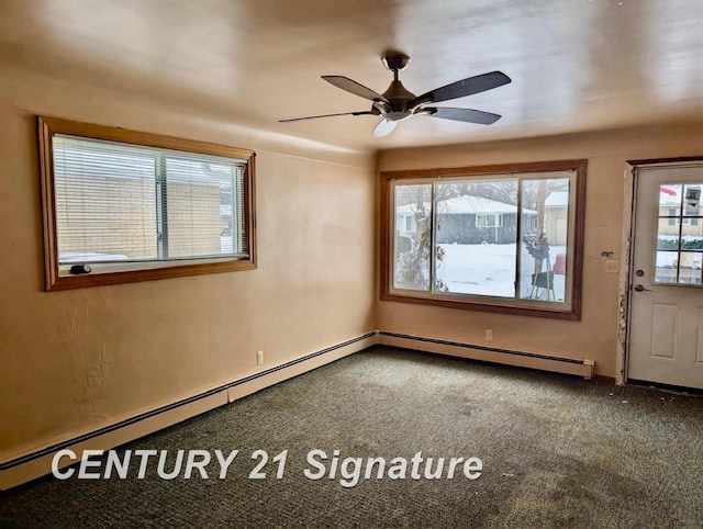 carpeted spare room with baseboard heating and a ceiling fan