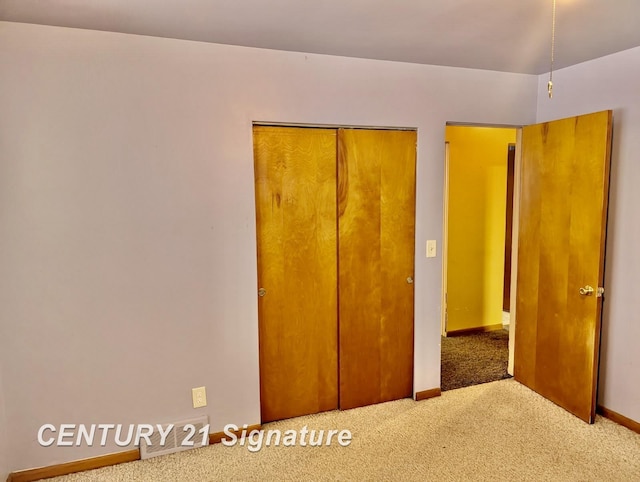 unfurnished bedroom featuring visible vents, baseboards, a closet, and carpet flooring