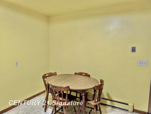 dining room with a baseboard heating unit and baseboards