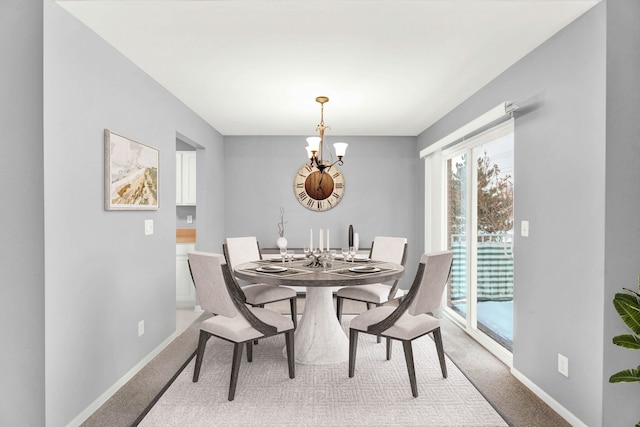 dining space with a chandelier and carpet