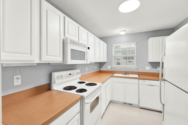 kitchen with white appliances, sink, and white cabinets