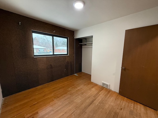 unfurnished bedroom featuring light hardwood / wood-style flooring and a closet