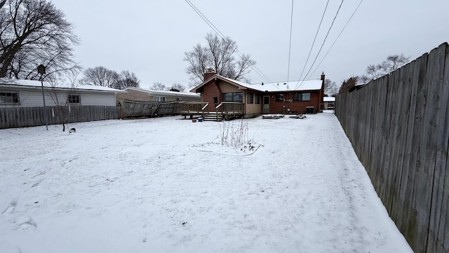 yard layered in snow featuring a deck