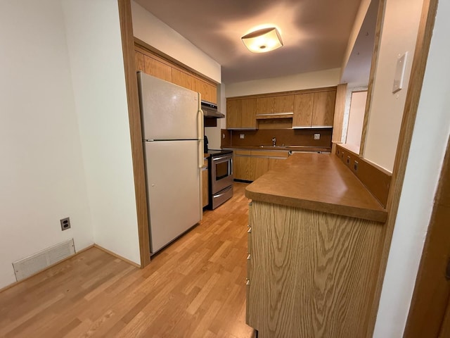 kitchen featuring white fridge, sink, light hardwood / wood-style flooring, and electric stove