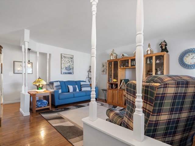 living room with decorative columns and dark hardwood / wood-style flooring