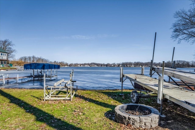 view of dock featuring a fire pit and a lawn