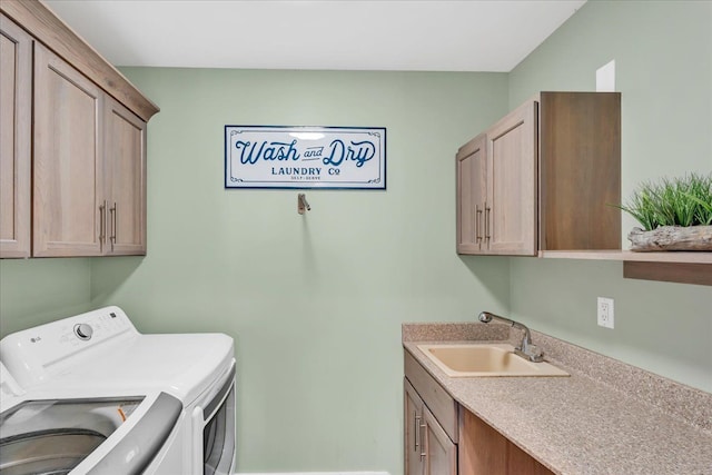 washroom featuring a sink, cabinet space, and separate washer and dryer