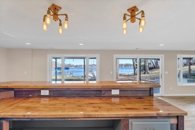 kitchen featuring a notable chandelier, butcher block countertops, recessed lighting, and a wealth of natural light