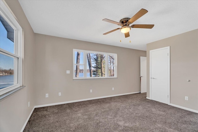 interior space featuring ceiling fan, baseboards, and carpet floors