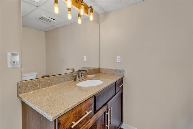 bathroom featuring vanity, toilet, a paneled ceiling, and visible vents