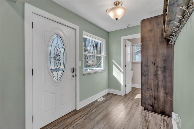 foyer with visible vents, baseboards, and wood finished floors