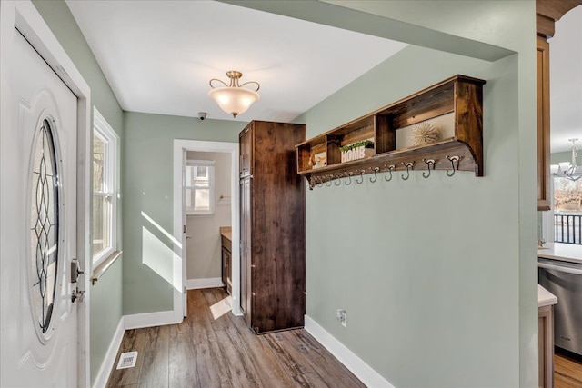 mudroom with visible vents, wood finished floors, and baseboards