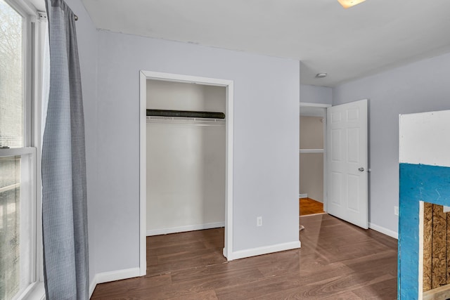 unfurnished bedroom featuring dark hardwood / wood-style floors and a closet