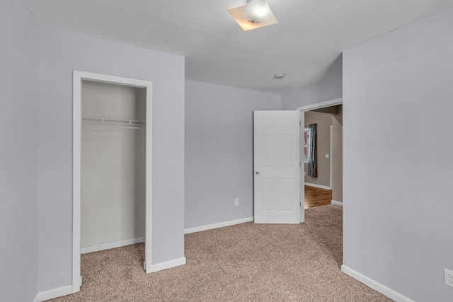 unfurnished bedroom featuring light colored carpet and a closet