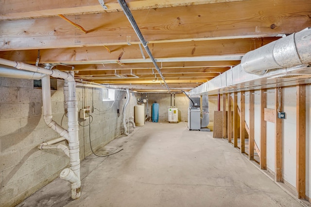 basement featuring heating unit and electric water heater