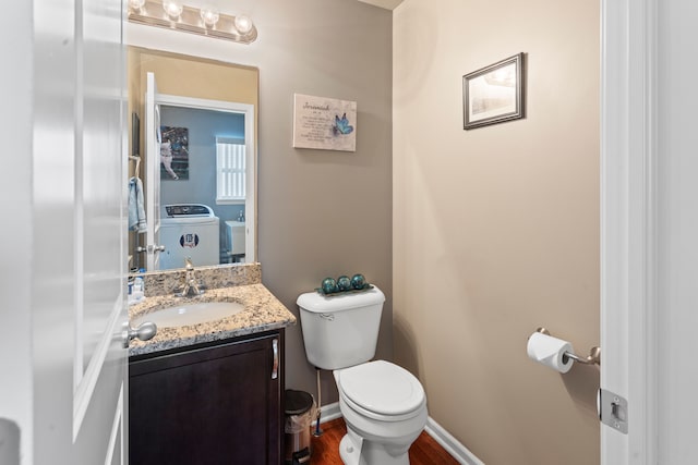 bathroom with vanity, wood-type flooring, washer and clothes dryer, and toilet