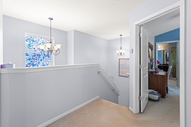 corridor featuring an inviting chandelier and carpet flooring