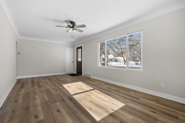 spare room with ornamental molding, dark hardwood / wood-style floors, and ceiling fan